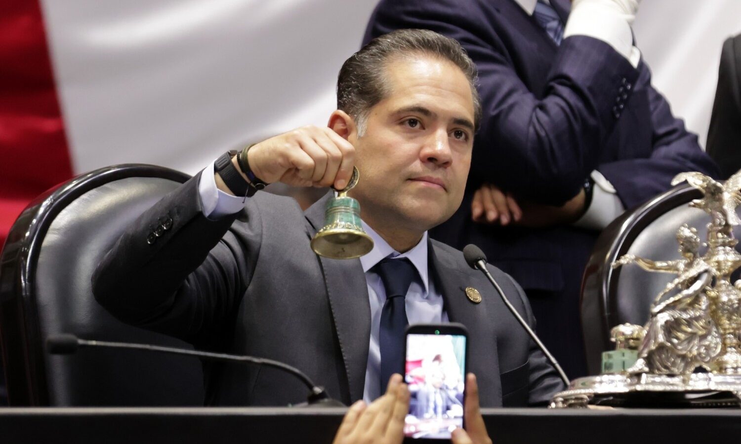 Legislador sostiene una campana durante una sesión en la Cámara de Diputados.